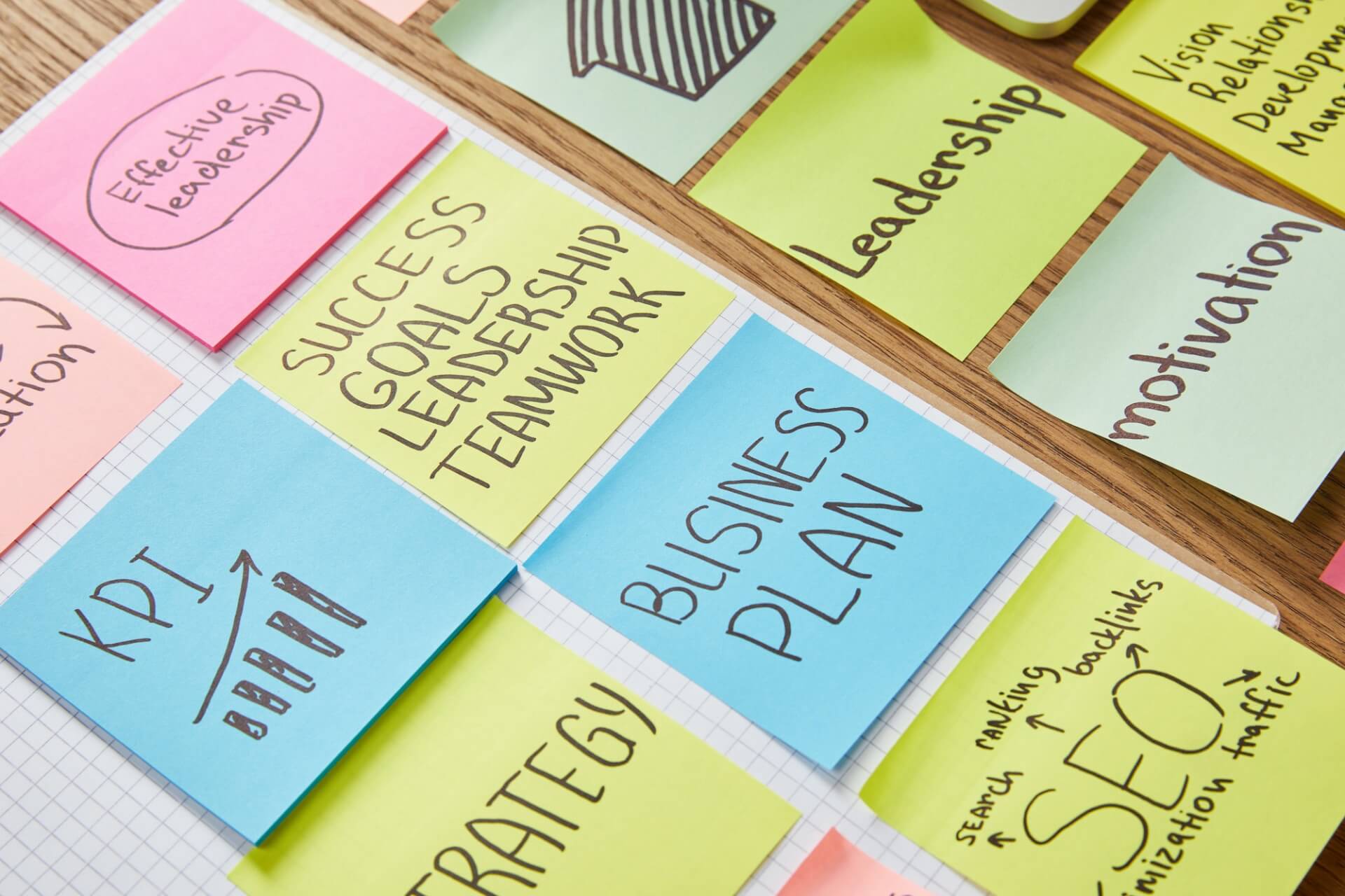 paper stickers with words teamwork, business plan and seo on tabletop